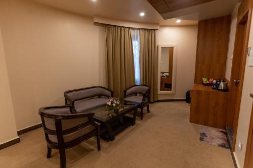 a hospital room with chairs and a table and a window at HOTEL HEIGA vns in Shillong