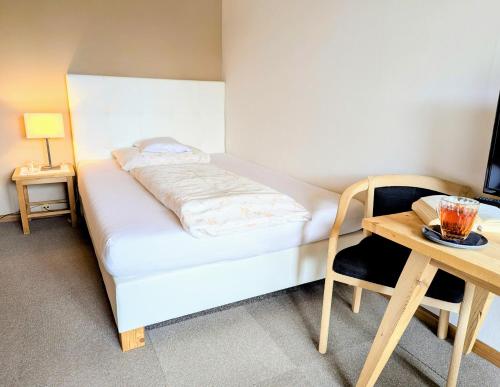 a small bedroom with a bed and a table at Gasthof Eggwirt in Ultimo