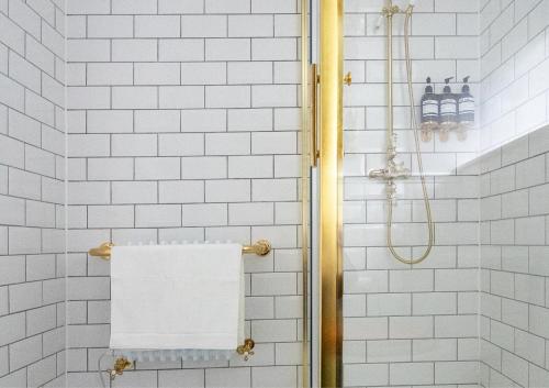 a shower with white subway tiles and a towel at The Hall - Historic Grade I-listed Jacobean Mansion in Bradford on Avon