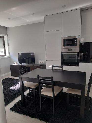 a kitchen with a table and chairs and a microwave at Amorosa Apart in Amorosa