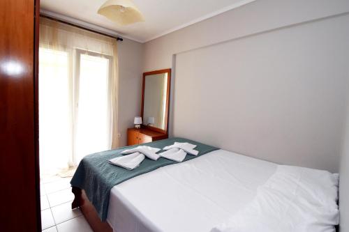 a bedroom with a bed with two towels on it at Epanomi Apartments in Epanomi