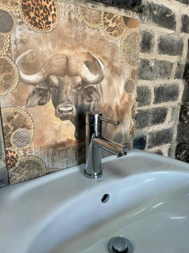 a bathroom sink with a deer head on the wall at Northern Rock Campsites in Otjiwarongo