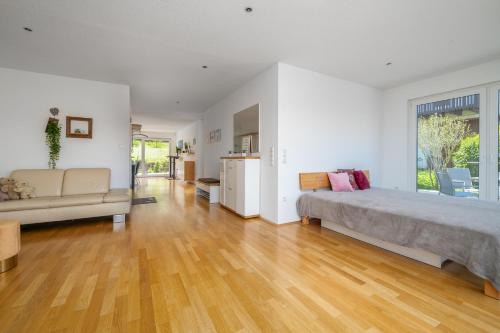 a bedroom with a large bed and a couch at Seeliebe und Gartenglück in Bodman-Ludwigshafen