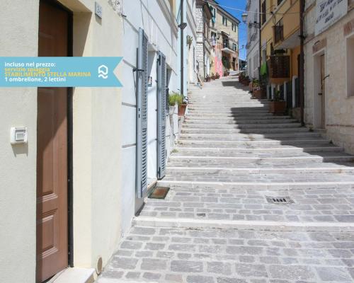 eine steinerne Gasse mit einem Schild an der Seite eines Gebäudes in der Unterkunft Numana, delizioso cielo-terra a 150mt dal mare - N099 in Numana