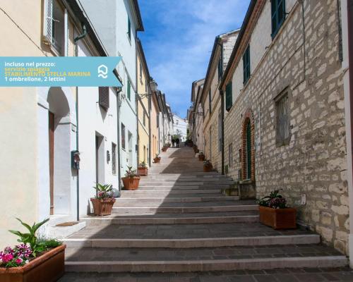 eine Gasse mit Steingebäuden und Topfpflanzen in der Unterkunft Numana, delizioso cielo-terra a 150mt dal mare - N099 in Numana