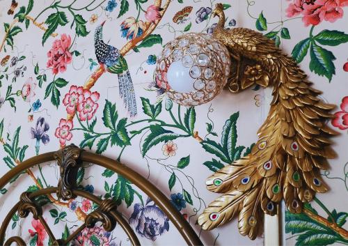 a wall with a floral wallpaper with birds on it at The Hall - Historic Grade I-listed Jacobean Mansion in Bradford on Avon
