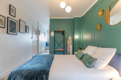 - une chambre avec des murs verts et un grand lit dans l'établissement Le Néo - Studio chic avec sa cour privative et fibre, à Bergerac
