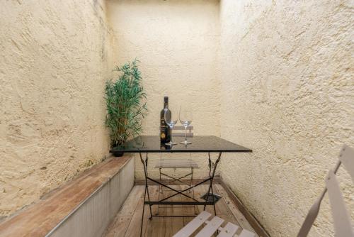 Una mesa con una botella de vino y dos copas. en Le Néo - Studio chic avec sa cour privative et fibre, en Bergerac