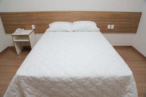 Un pat sau paturi într-o cameră la Rota Hoteis Itumbiara