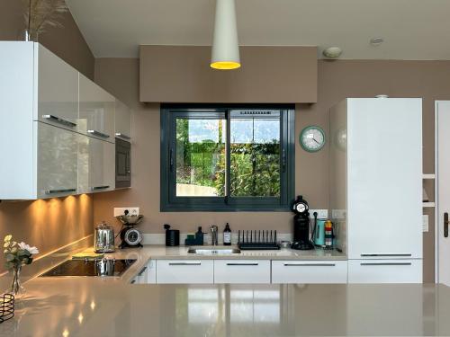 une cuisine avec un évier et une fenêtre dans l'établissement La Bergerie - Modern villa with pool in private domain, à Saint-Paul-de-Vence