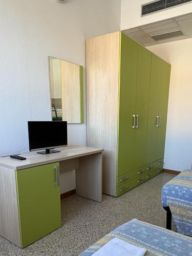 a room with a desk with a computer and a mirror at Rooms Casa Celeste sul Mare in Cesenatico