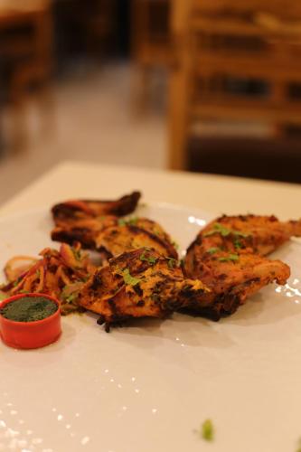 a white plate with food on a table at ROYAL ROSETTE LAKE VIEW Bhimtal in Nainital