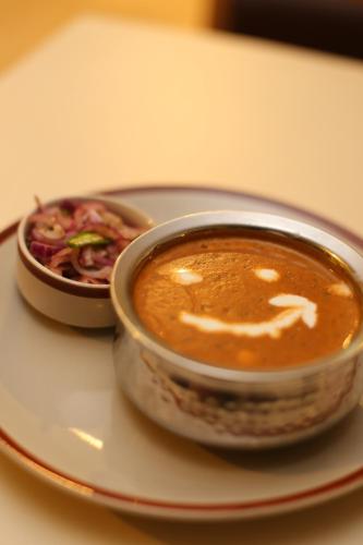 a bowl of soup on a plate with a salad at ROYAL ROSETTE LAKE VIEW Bhimtal in Nainital