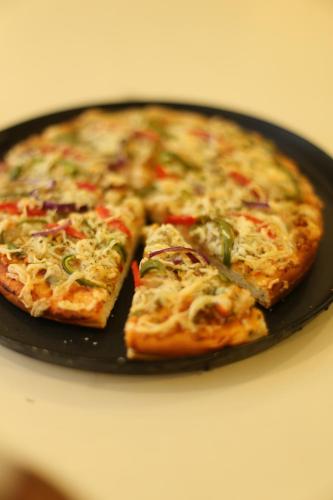 two slices of pizza sitting on a pan at ROYAL ROSETTE LAKE VIEW Bhimtal in Nainital