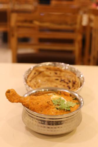 two dishes of food sitting on a table at ROYAL ROSETTE LAKE VIEW Bhimtal in Nainital