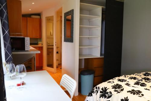 una camera con tavolo bianco e cucina di J home a Villeneuve-le-Roi
