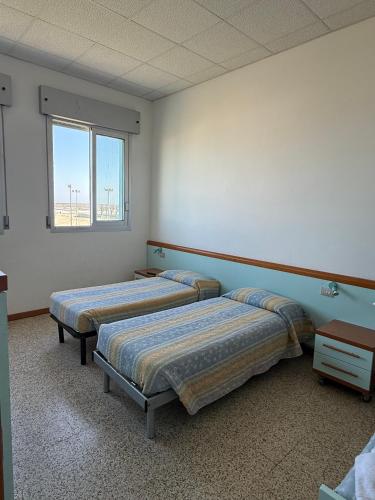 a room with two beds and a window at Rooms Casa Celeste sul Mare in Cesenatico