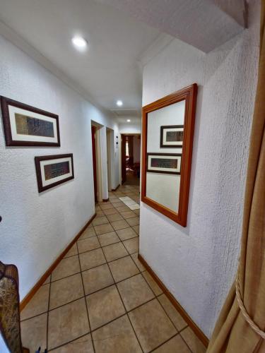 a hallway with white walls and pictures on the wall at Kruger Park Lodge 243 in Hazyview