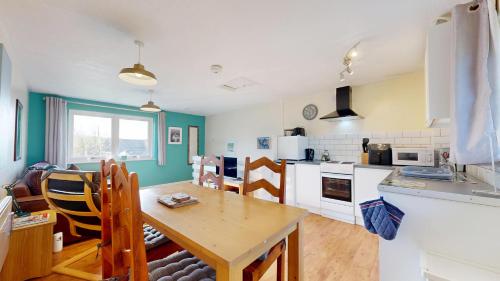a kitchen with a table and a dining room at Bryntin in Penzance