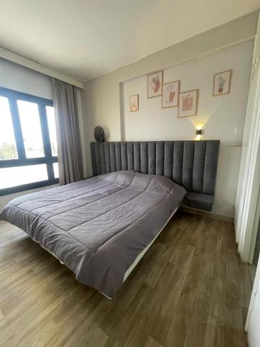 a large bed in a bedroom with a wooden floor at Hotel el Fawz in Monastir