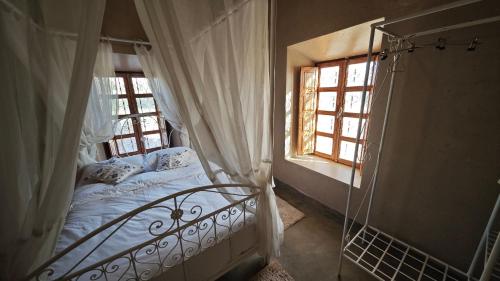 a bedroom with a bed and a window at kasba Harmony in Oulad Saïd