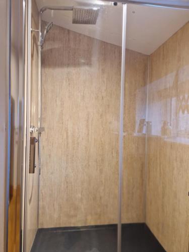 a shower with a glass door in a bathroom at Borlum House in Thurso
