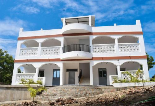 a white house with a staircase in front of it at Mangrove Sunset View Villa in Malindi