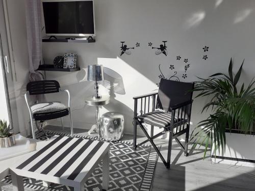 un salon avec deux chaises et une télévision dans l'établissement Duplex dernier étage terrasse sud La Baule plage 8mn à pied, à La Baule