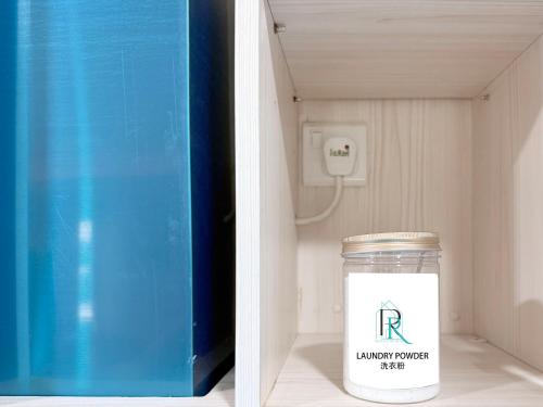 a jar of laundry powder next to a blue box at Restful Respite Tanjung Aru Inifnity Pool 2BR in Kota Kinabalu