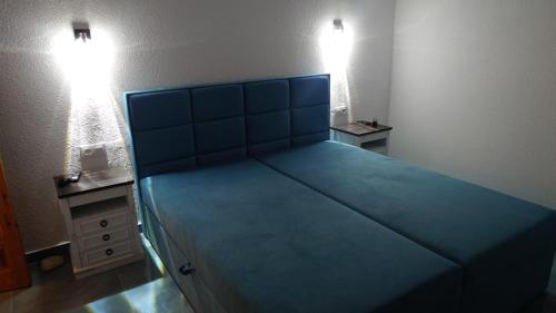 a large bed with a blue headboard in a bedroom at Apartamento Buena Vista in Mojácar