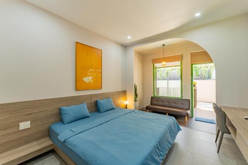 a bedroom with a blue bed and a table at Na Garden Homestay in Hue