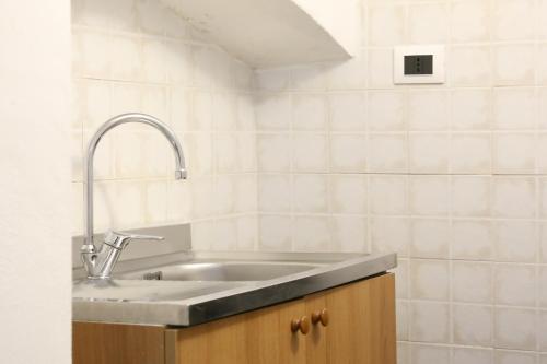 a sink in a kitchen with white tiles at Corte Micetti 2- Centro storico in Gallipoli