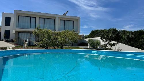 a large blue swimming pool in front of a building at Casa Magnólia in Matas