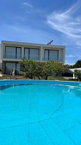 a large blue swimming pool in front of a house at Casa Magnólia in Matas