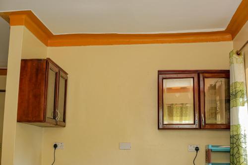a kitchen with wooden cabinets and a window at Tranquility in Nakisunga