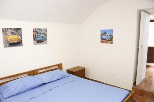 a bedroom with a blue bed with pictures on the wall at Corte Micetti 1- Centro storico in Gallipoli
