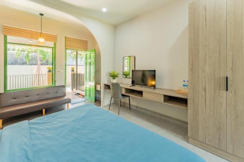 a bedroom with a blue bed and a television at Na Garden Homestay in Hue