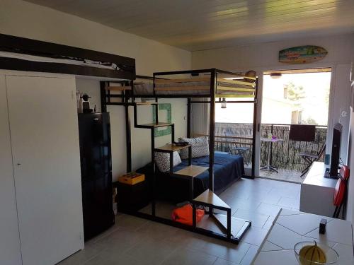 une chambre avec un lit superposé et un salon dans l'établissement Studio Corse avec acces direct à la plage La Liscia, à Calcatoggio