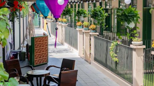 a balcony with tables and chairs and potted plants at Na Garden Homestay in Hue