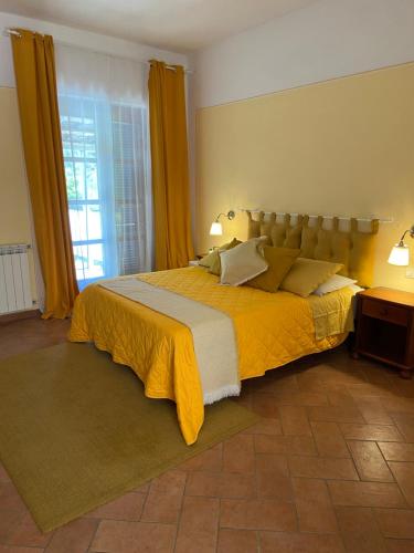 a bedroom with a large bed with a yellow blanket at Valle dei Mulini B&B in Marciana
