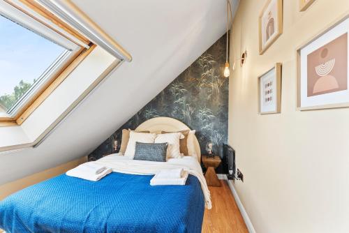 a bedroom with a blue bed in a attic at Cambridge 2 Bed House near City Centre & Science Park in Milton