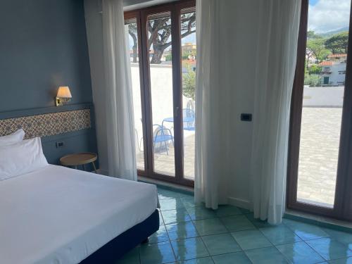 a bedroom with a bed and a view of a balcony at Hotel Marad in Torre del Greco