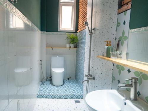a bathroom with a toilet and a sink at Villa Nhà có hai cây Tùng in Bao Loc