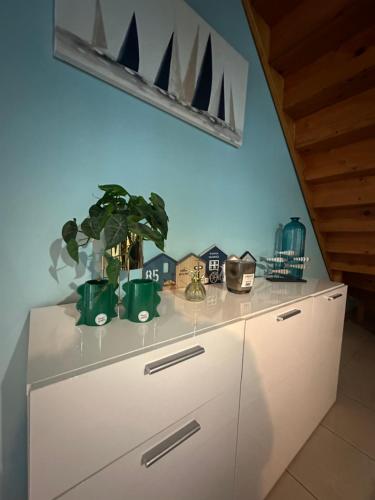 a white dresser with plants on top of it at Le 8 appartement - Le Duplex III - parking sur demande in Mâcon