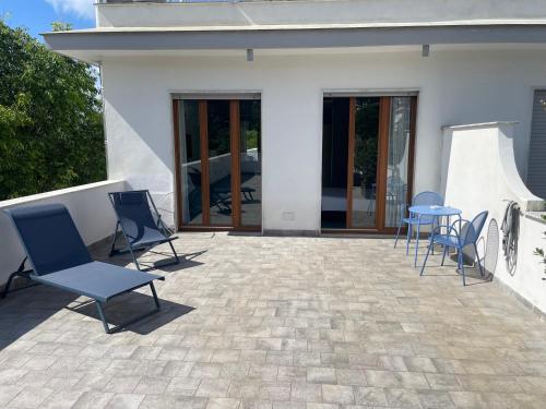 a patio with chairs and tables in front of a house at Hotel Marad in Torre del Greco