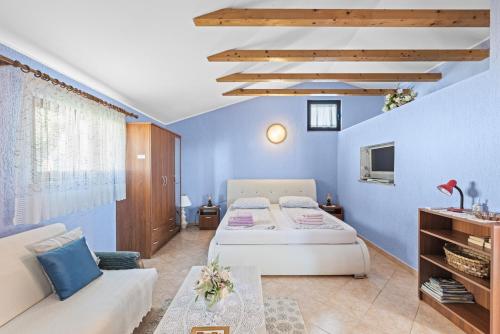 - une chambre bleue avec un lit et un canapé dans l'établissement Casa Jelena with Shared Pool, à Kaštelir