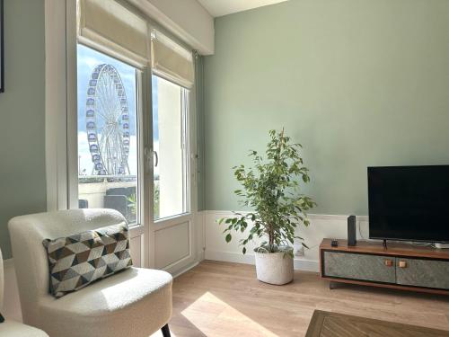 un salon avec une chaise, une télé et une roue dans l'établissement SEA VIEW terrace and garage in Berck-Plage, à Berck-sur-Mer