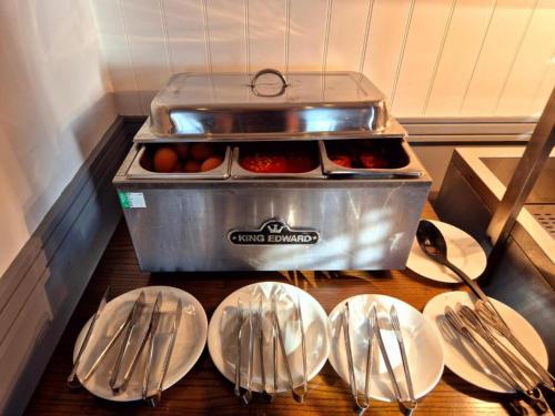 a kitchen with plates and silver utensils on a table at Boston Supreme Hotel in Boston