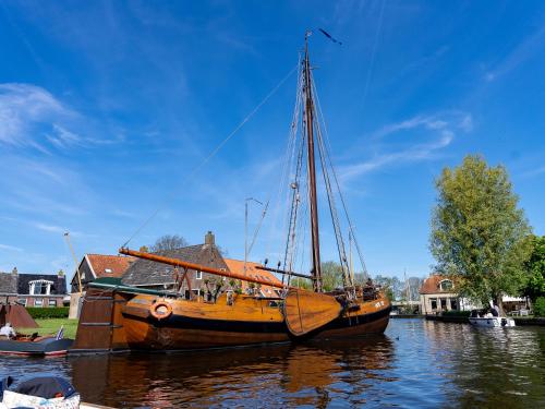 a wooden boat is docked in the water at Safaritent Heeg 4 persoons in Heeg