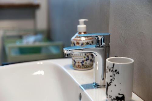 a sink with a faucet and a cup next to it at Villa del Sole - Lake Como Garden in Cernobbio